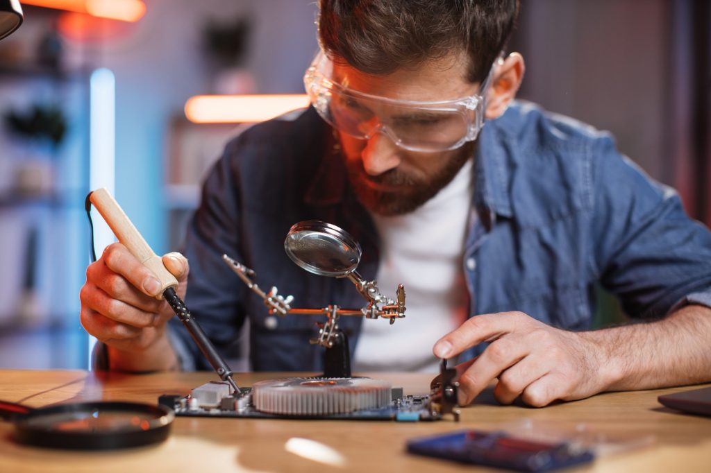 Repairman soldering video card from portable computer